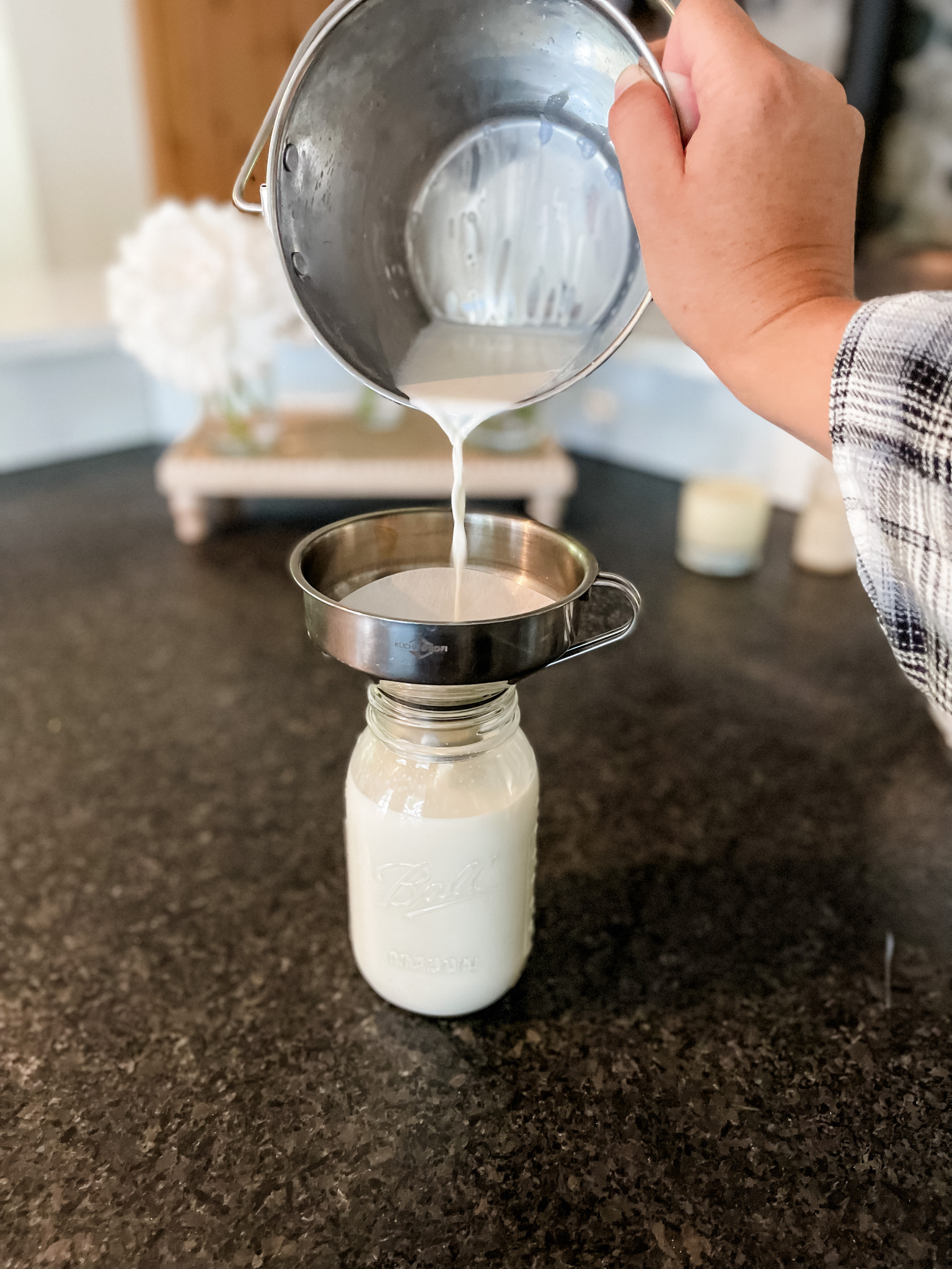 Straining raw goats milk Pivot Farm